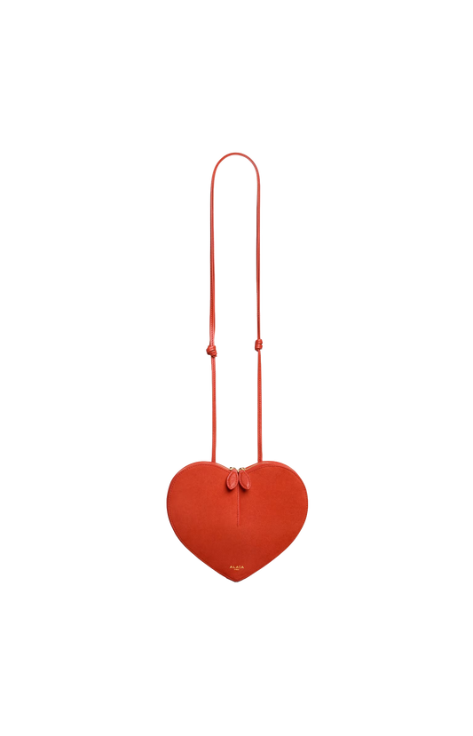 Red heart-shaped bag with a strap on a white background