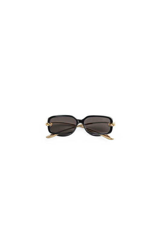 Sunglasses Bottega Veneta with gold frame and black lenses on a white background 