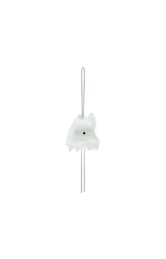 White decorative item with a long thin rod on a white background